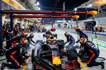 화려한 색상의 레이싱카를 빠르게 정비하는 피트 크루의 긴장감 넘치는 순간을 담은 모습이다.